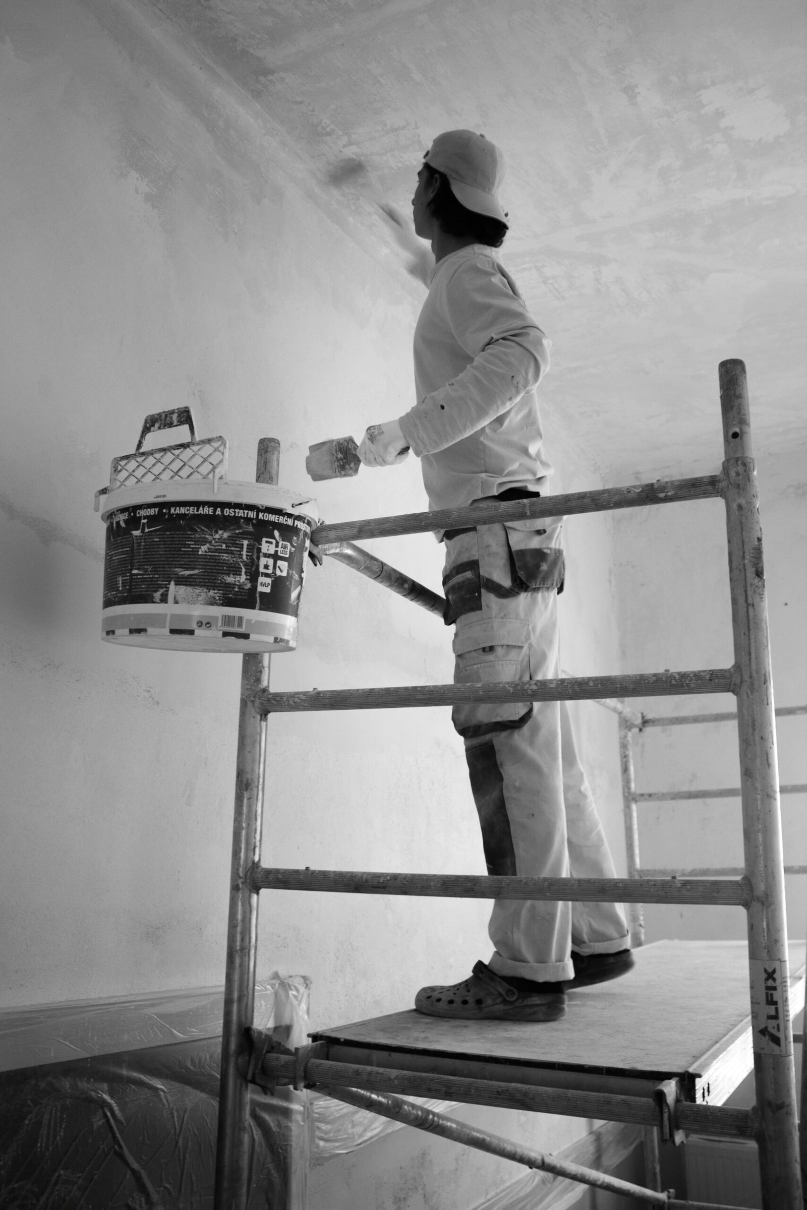 Maler streicht eine Wand mit der Farbrolle